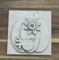 Unfinished pumpkin frame insert with a little bird and layered flower with a button-style center