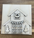 Unfinished birch Christmas barn frame insert with layered barn doors, wreath and bow, holiday lights, and two evergreen trees.