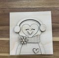 Unfinished birch penguin frame insert with earmuffs, scarf, layered snowflake, and heart.