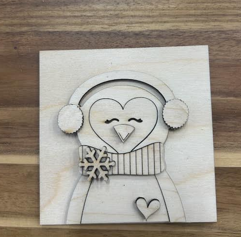 Unfinished birch penguin frame insert with earmuffs, scarf, layered snowflake, and heart.