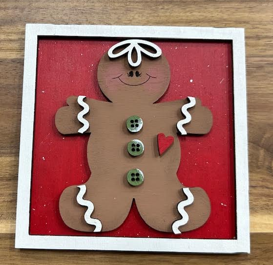 Finished gingerbread man frame insert shown in a white frame against a red background