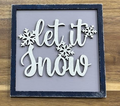 Hand-painted Let It Snow frame insert with white lettering and snowflakes on a gray background, shown in a dark frame