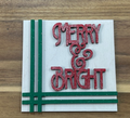Merry and Bright finished frame insert with sparkly red lettering and green border stripes on a white background.