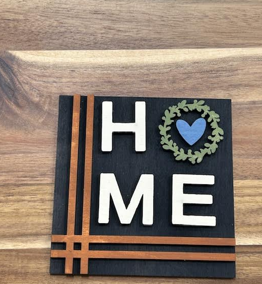 Finished HOME frame insert with white letters on black, green wreath, blue heart, and brown line accents.