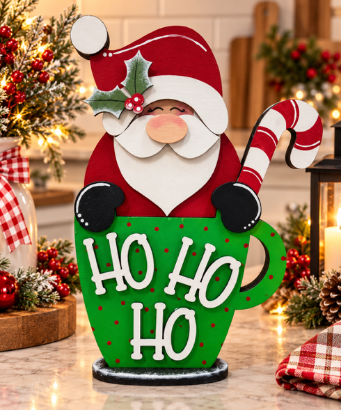 Finished Santa shelf sitter in a green Ho Ho Ho mug with red dots, holly, and a red-and-white candy cane