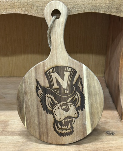 Old Nevada Wolf Pack logo laser engraved on a small round acacia wood charcuterie board with handle