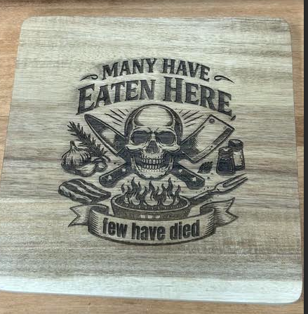 Square 8 x 8 inch acacia wood trivet engraved with Many Have Eaten Here, Few Have Died